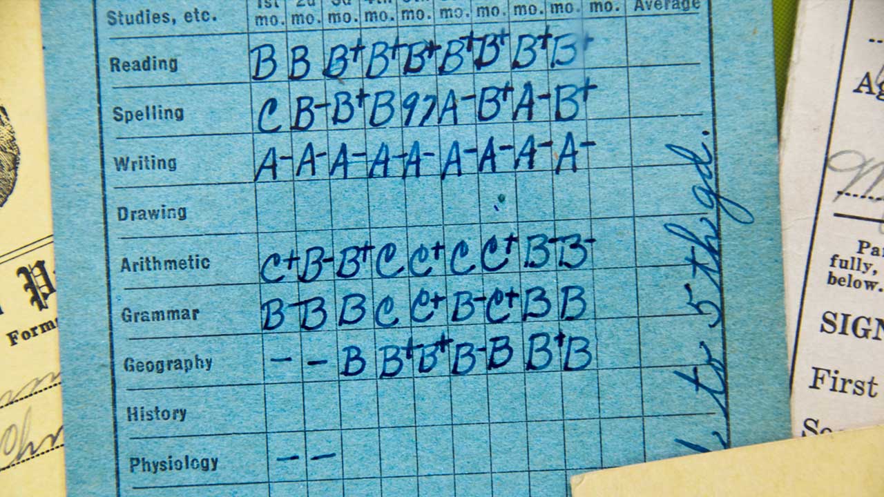 A blue report card shows handwritten 4th quarter grades for subjects like reading, spelling, writing, arithmetic, and geography, with blank spaces for history and physiology.